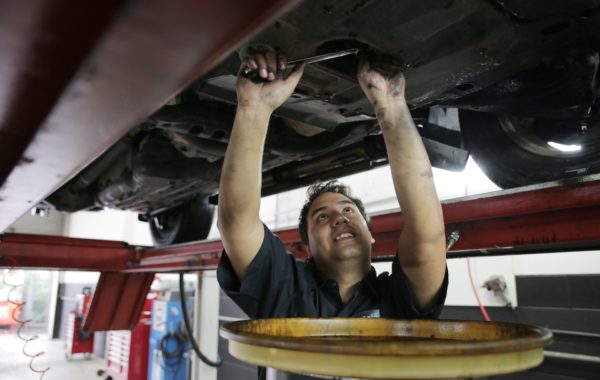 A mechanic clearing out a vehicle’s oil mid-service