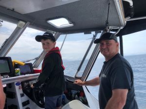 Nick Young and son Mason navigating waters in a boat